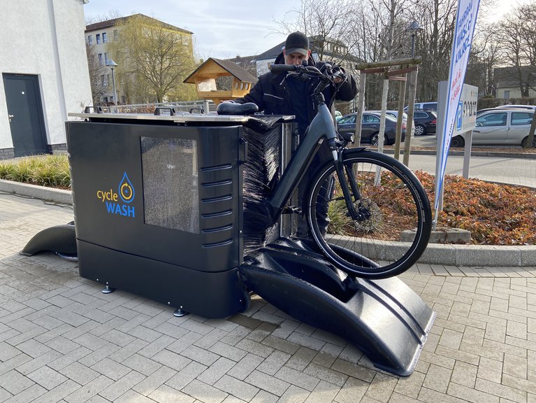 Björn Erwin schiebt das Rad durch die Wasch-Anlage.