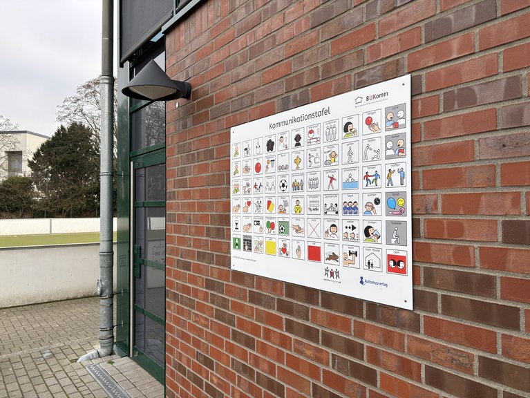 Die Tafel mit den UK-Symbolen hängt am Sportzentrum bei den Spielfeldern.